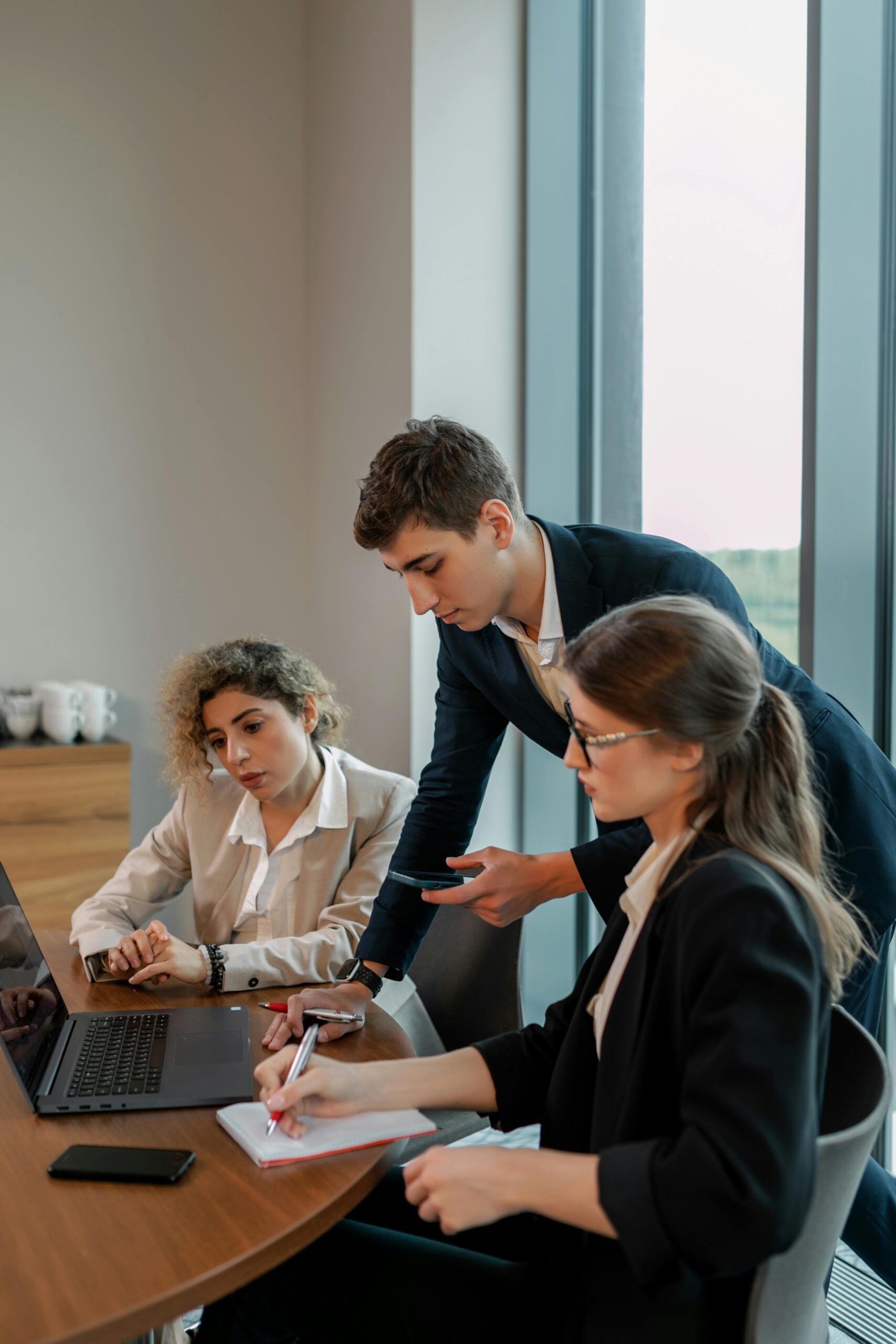 Asesores financieros reunidos con clientes en una mesa de trabajo analizando estrategias de inversión y planificación financiera.